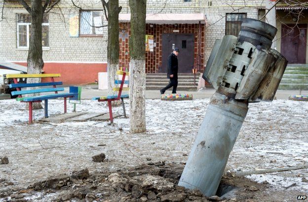 A man passes an unexploded rocket in Kramatorsk, eastern Ukraine, 11 February