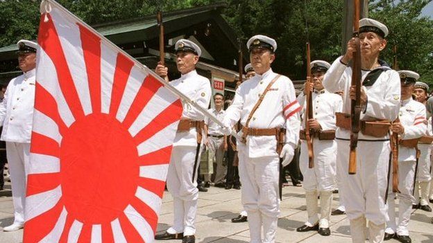 File photo of Japanese war veterans standing to attention with the navy flag as they pay their respect to the war dead at Tokyo's Yasukuni Shrine