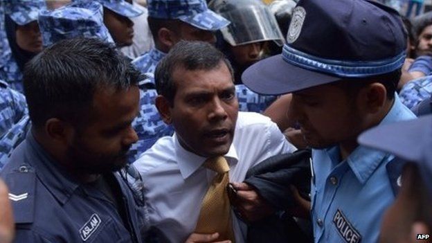 Maldives police try to move former President Mohamed Nasheed (C) during a scuffle as he arrives at a courthouse in Male 23 February 2015.