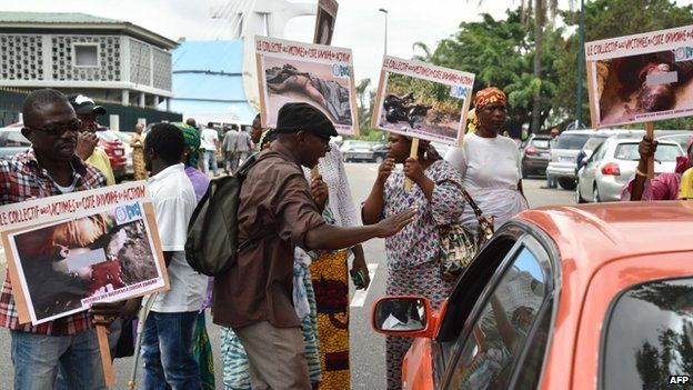 Relatives and friends of victims of the 2010-2011 post-electoral crisis in Ivory Coast holds up images of the slain victims during a protest on February 23, 2015 in front of the Palace of Justice in Abidjan