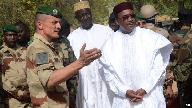 Niger's President Mahamdou Issoufou (R) listen to a French military officer in Diffa, eastern Niger, on 21 February 2015