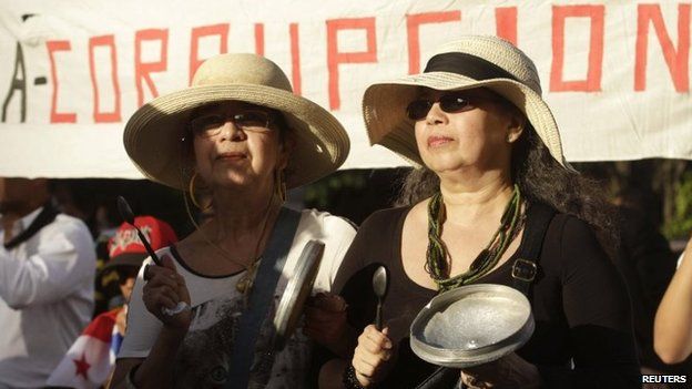 Women hit pans during an anti-corruption march in Panama City on 29 January, 2015.