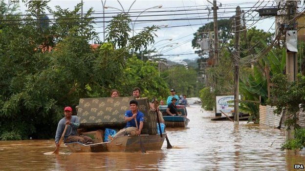 Affected residents try to save some furniture after heavy rain led to flooding in Cobija on 24 February 2015