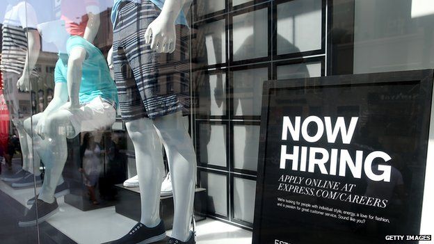 Shop window with 'Now hiring' sign