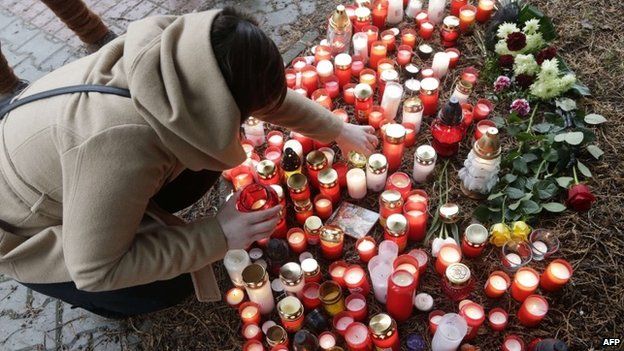 A woman places a candle on February 25, 2015 in front of a building where a gunman opened fire in a restaurant in Uhersky Brod, Czech Republic