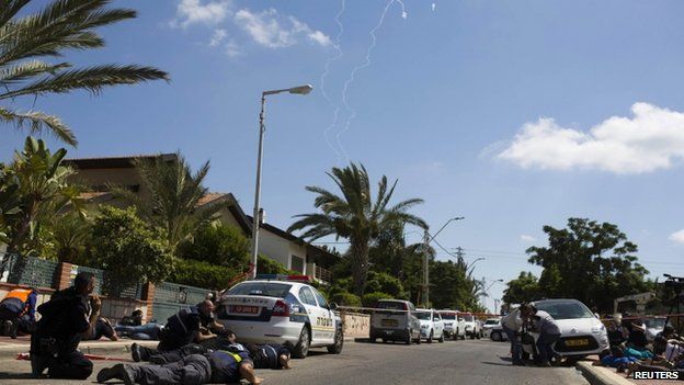 People in Israel's city of Ashkelon take cover as a siren sounds to warn of incoming rockets from Gaza. Photo: July 2014