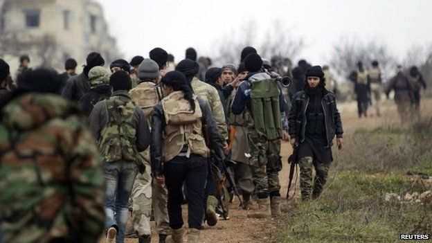 Бойцы бригады Сукур аль-Шам, входящей в Свободную сирийскую армию, идут со своим оружием