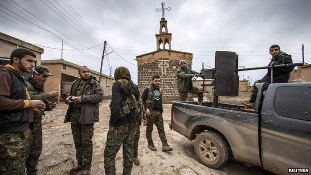 Members of the Syrian Kurdish YPG militia stand near a church in the Assyrian village of Tal Jumaa, north of Tal Tamr (25 February 2015)