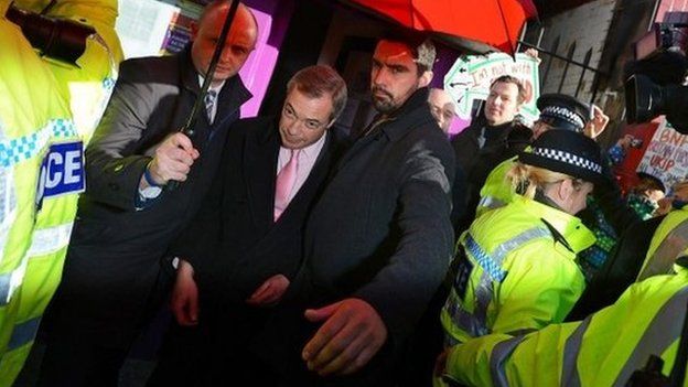 Nigel Farage leaves under police escort after a protest in Rotherham