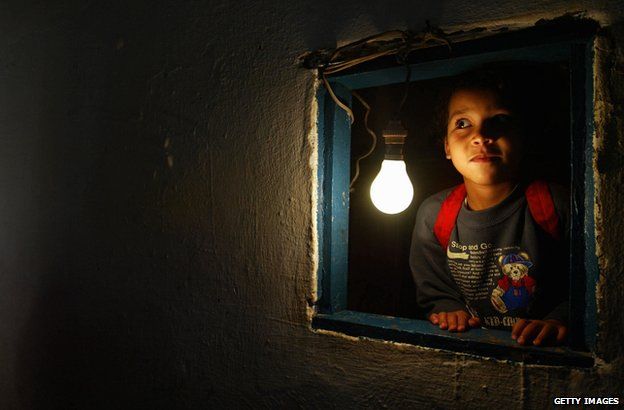 A girl in Morocco next to a newly-installed lightbulb