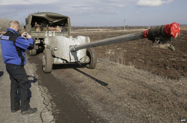An OSCE observer takes a picture of Ukrainian artillery near Soledar, in the Donetsk region, 27 February