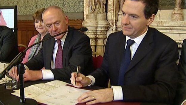 Chancellor George Osborne (right) signing the devolution agreement. He is sat next Sir Richard Leese, deputy leader of Greater Manchester Combined Authority