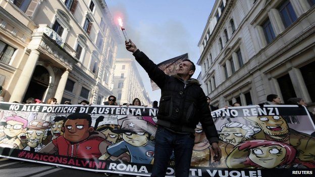 A demonstrator holds up a flare during a protest against a rally held by Northern League party leader Matteo Salvini in downtown Rome (28 February 2015)