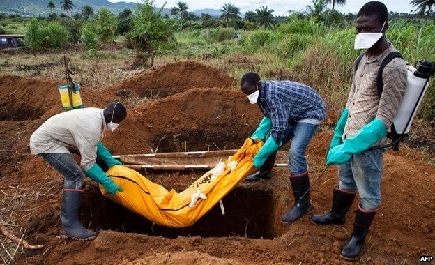 Volunteers bury an Ebola victim in Waterloo, southeast of Freetown - 7 October 2014
