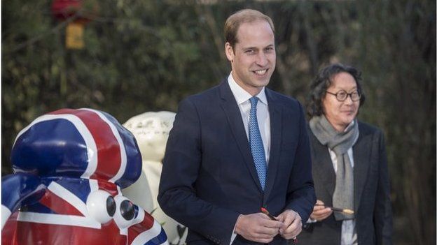 Britain's Prince William, Duke of Cambridge, poses after painting the eye of a "Shaun the Sheep" sculpture at the British Ambassador's official residence in Beijing, 2 March 2015