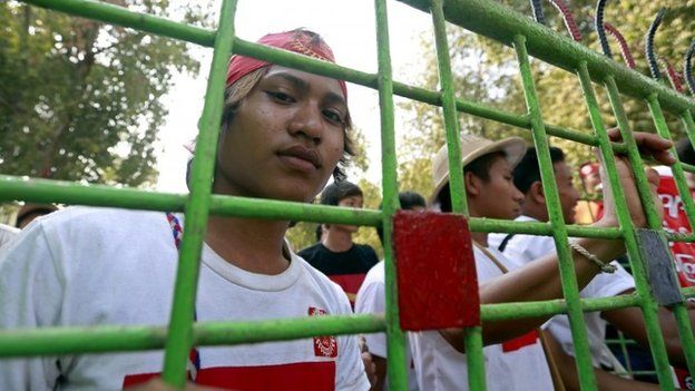 A student looks from behind a gate at the protest camp in Letpadan, Bago division, Myanmar, 02 March 2015.