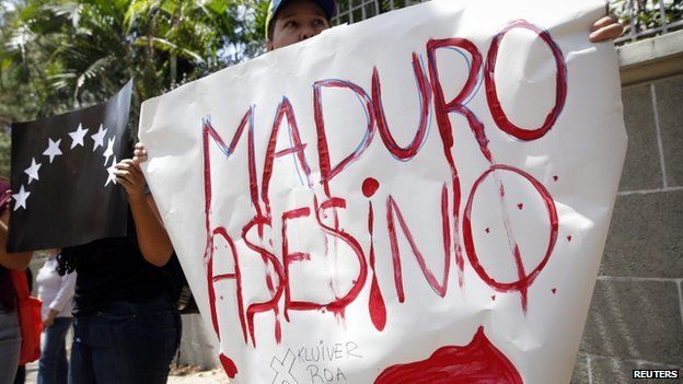 Opposition supporter holds a sign during a gathering to protest the death of an student in Tachira State, in Caracas