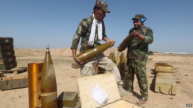 Shia militiamen prepare shells for an artillery gun outside Tikrit (2 March 2015)