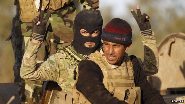 Shia militiaman makes victory gestures in Salahuddin province, Iraq (2 March 2015)