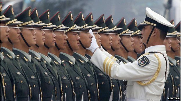 An officer of the Chinese People's Liberation Army (PLA) uses a string to ensure that the soldiers making up a guard of honour, stand in a straight line before an official welcoming ceremony for Afghan President Hamid Karzai outside the Great Hall of the People in Beijing in this 27 September 2013 file photo