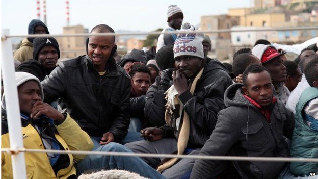 Migrants wait to disembark from an Italian Coast Guard vessel after being rescued in Porto Empedocle, Sicily,