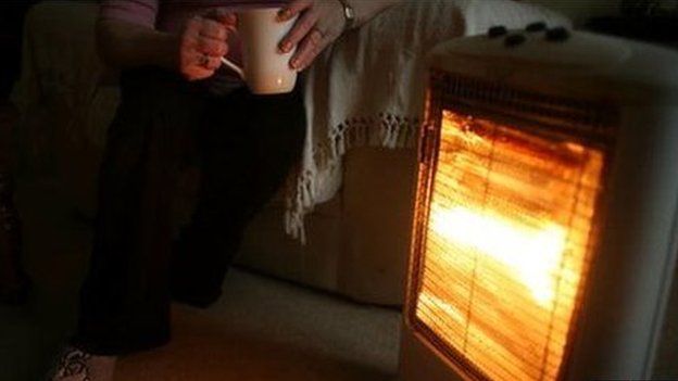 A heater and a man holding a cup of tea