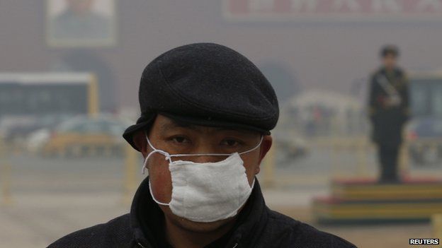 A man wears a mask as he makes his way during a polluted day at Tiananmen Square in Beijing 15 January 2015