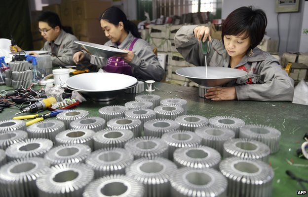 Workers assemble LED lights at a factory in Zouping, in eastern China's Shandong province on 31 December 2014
