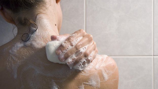 Woman soaping her back in shower