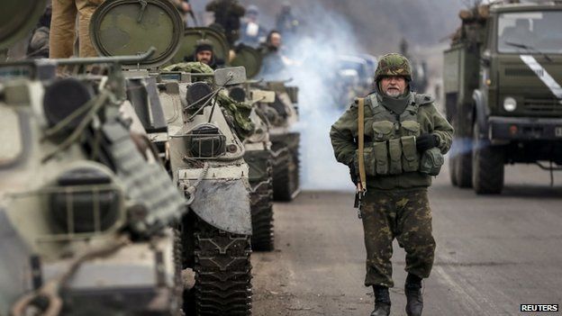 Members of the Ukrainian armed forces and armoured personnel carriers preparing to pull back from Debaltseve region