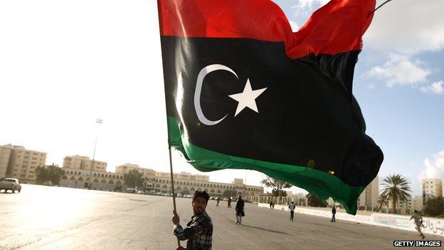 A man holding the Libyan flag