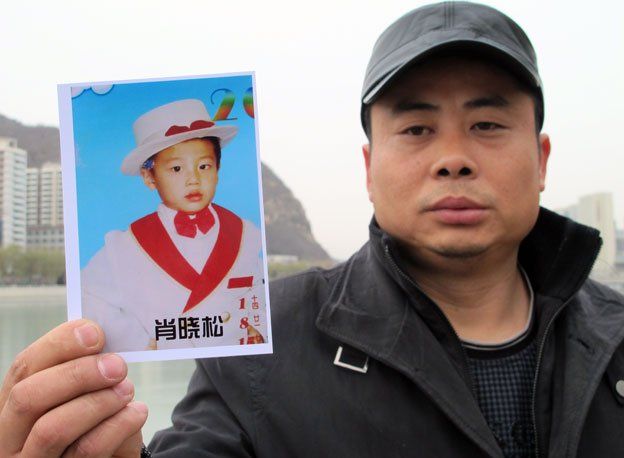 Xiao with a picture of his son
