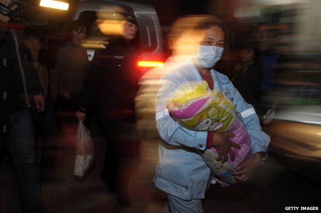 December 18, 2012 shows a medic (C) holding a rescued baby in her hands in Xichang, southwest China's Sichuan province