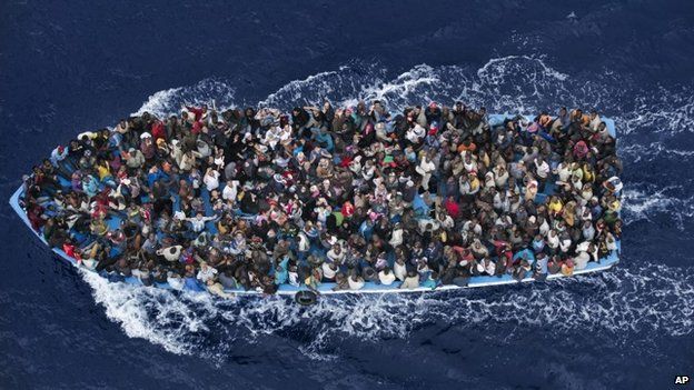 A boat packed with refugees tries to cross the Mediterranean