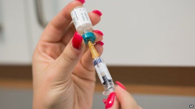 A nurse assistant prepares a measles vaccination in Berlin, Germany