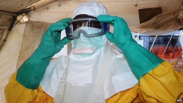 A member of Medecins Sans Frontieres (MSF) or Doctors Without Borders, putting on protective gear at the isolation ward of the Donka Hospital in Conakry 28 June 2014