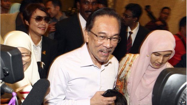 In this Tuesday, 10 Feb 2015 file photo, Malaysian opposition leader Anwar Ibrahim, center, arrives at court house in Putrajaya, Malaysia.