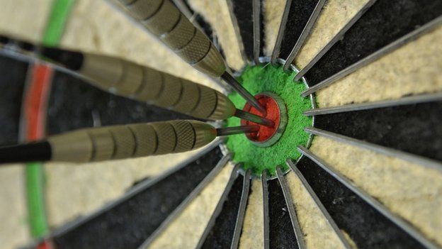 Three darts in the bullseye of a dart board
