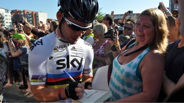 Mark Cavendish signs a book for a fan in Ipswich