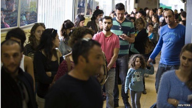 Israeli voters wait in line at a polling station in Tel Aviv