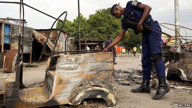 A policeman inspects damage outside a police station that was attacked during violent protests in Kinshasa, Democratic Republic of Congo on 23 January 2015
