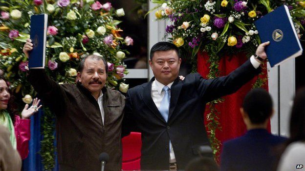 In this file photo taken on 14 June, 2013, Chinese businessman Wang Jing holds up a concession agreement for the construction of a multibillion-dollar canal at the Casa de los Pueblos in Managua