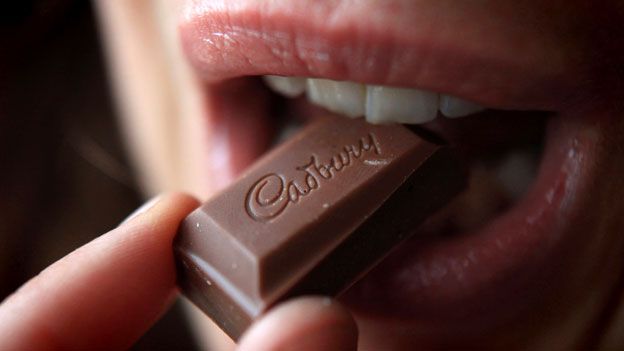 Woman tasting a chunk of Cadbury's chocolate