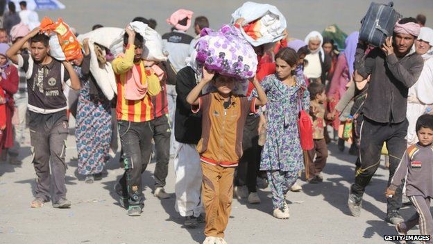 Displaced Iraqi families from the Yazidi community cross the Iraqi-Syrian border at the Fishkhabur crossing, in northern Iraq, on August 13, 2014.