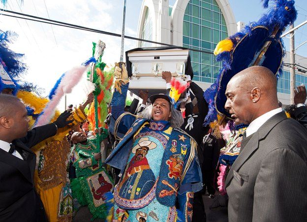 Pallbearers lift the casket three times before putting it in the hearse during the funeral of Theodore Emile 'Bo' Dollis, Big Chief of the Wild Magnolias, at Xavier Convocation Center on January 31, 2015 in New Orleans, Louisiana