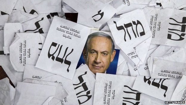 Copies of ballots papers and campaign posters for Israel's Prime Minister Benjamin Netanyahu's Likud Party lie on the ground in the aftermath of the country's parliamentary elections, early on 18 March
