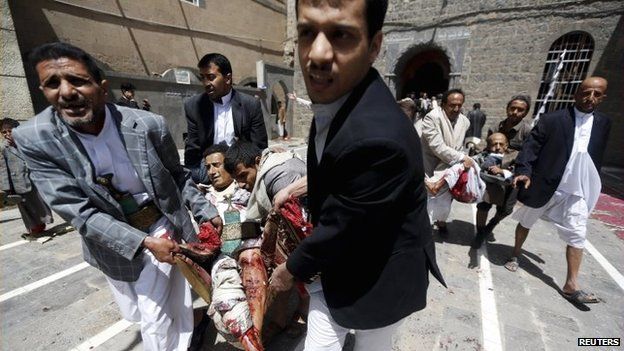 People carry the injured out of a mosque which was attacked by a suicide bomber in Sanaa, Yemen, 20 March 2015