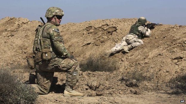 A US soldier trains an Iraqi security forces member in a shooting drill in Taji, north of Baghdad, Iraq, 21 March 2015