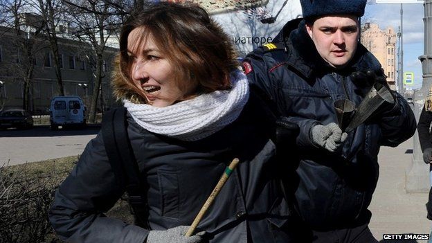 A woman opposed to a far-right forum in St Petersburg is removed by police, 22 March 2015