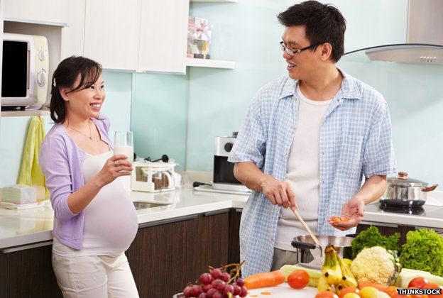 A pregnant woman and a man preparing food